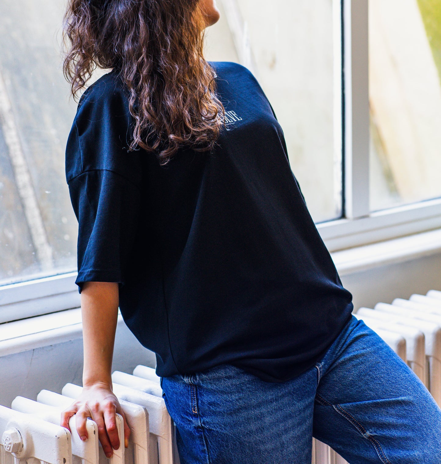 Side view of organic cotton t-shirt in black with powerful “EVOLVE” print, combining comfort with mindful fashion.