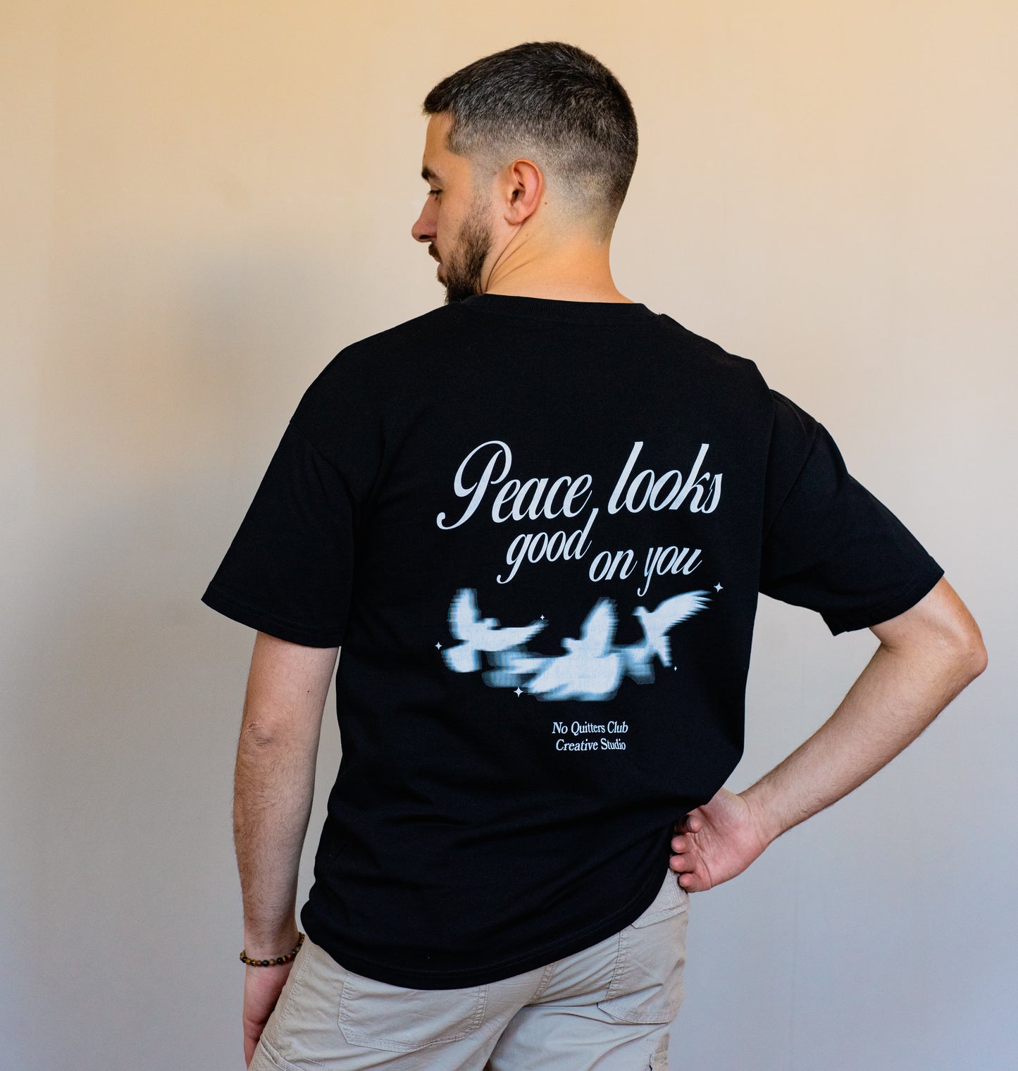 Unisex inspirational black t-shirt with mental health message “Peace Looks Good on You” printed on organic cotton for modern comfort.