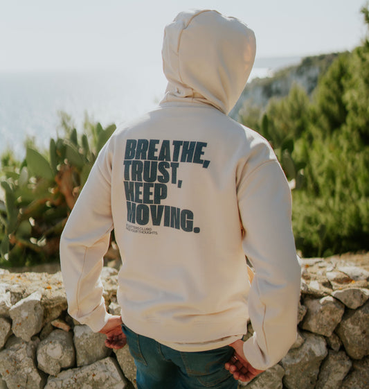 Detailed 'Breathe, Trust, Keep Moving' quote on soft organic cotton. Close-up of mindful message. High-quality, sustainable streetwear for daily affirmation.