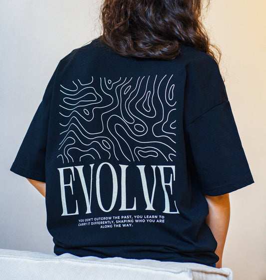 Back detail of oversized black t-shirt with “EVOLVE” message, designed for those embracing transformation and growth.