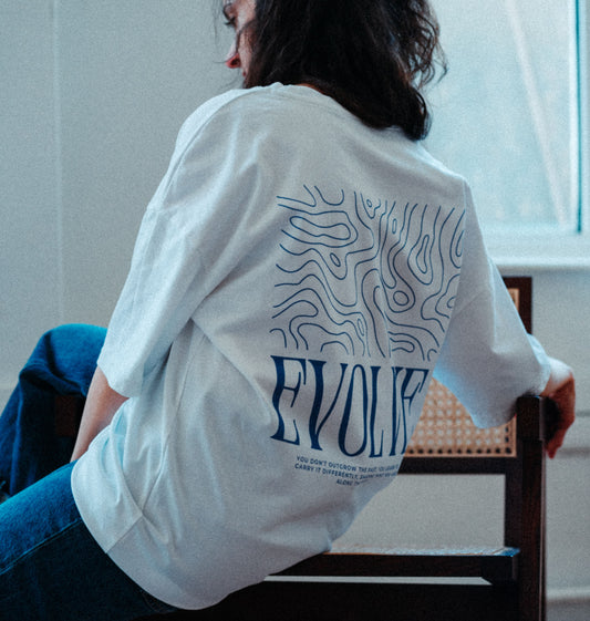 Minimal white t-shirt with “EVOLVE” design, ethically made from soft organic cotton for conscious streetwear lovers.