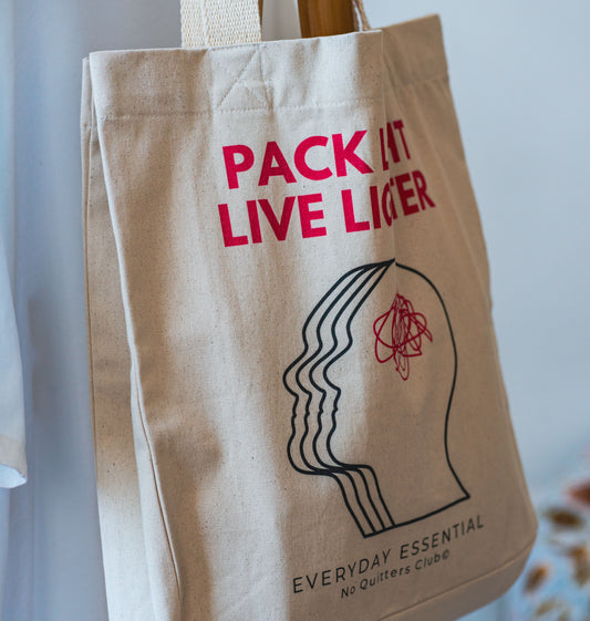 Close-up of quote "Pack Light, Live Lighter" printed on organic cotton tote – sustainable fashion for conscious consumers