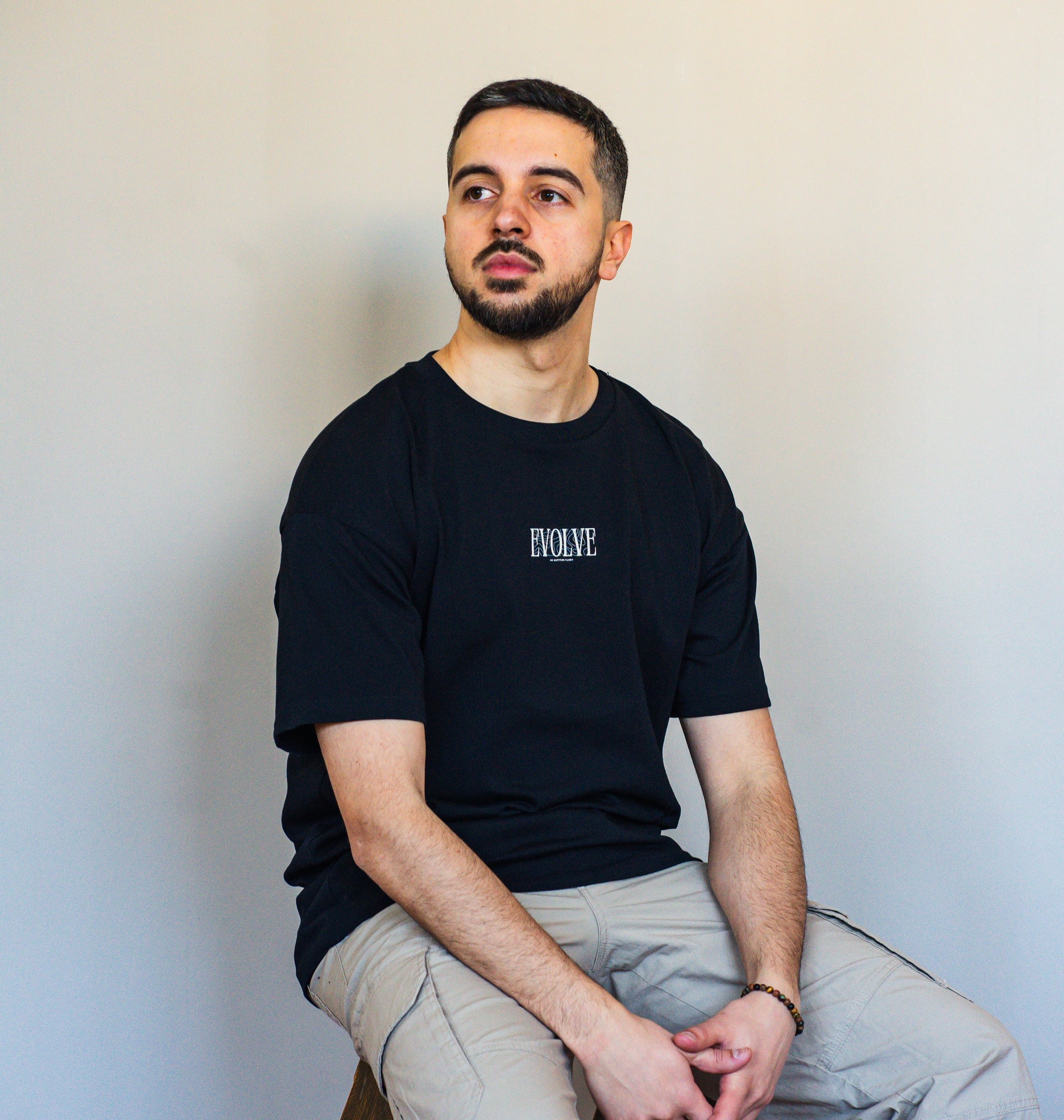 Oversized unisex black t-shirt with inspiring EVOLVE quote, crafted in premium organic cotton for elevated everyday looks.