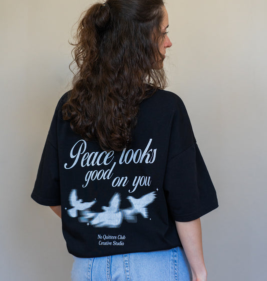 Black relaxed-fit oversized t-shirt with empowering quote, ethically made in organic cotton for eco-conscious fashion lovers.