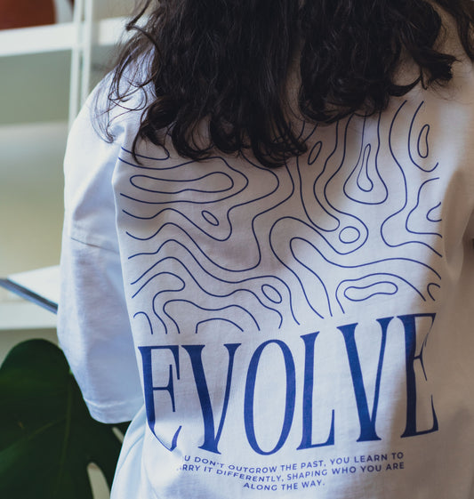 Back of white oversized t-shirt with EVOLVE quote—designed to inspire change and crafted sustainably in organic cotton.